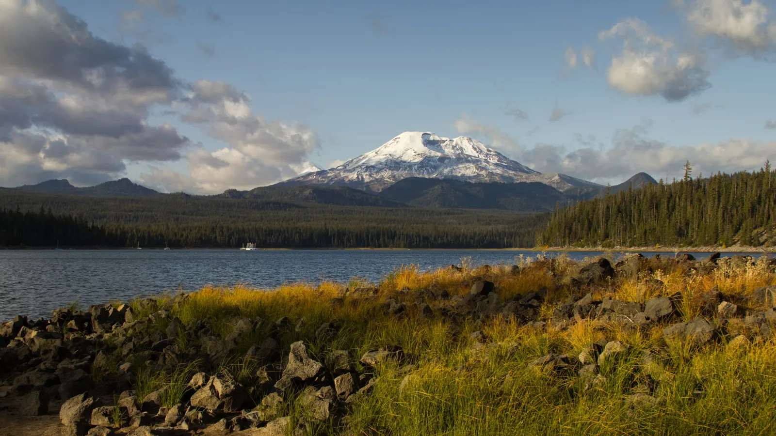 Elk Lake in fall, with golden grass and lava rock in front and South Sister across the water