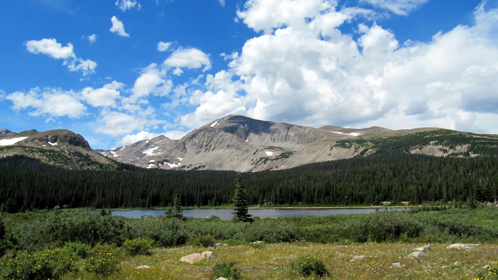Brainard Lake below forest and bare Indian Peaks summits on a sunny day