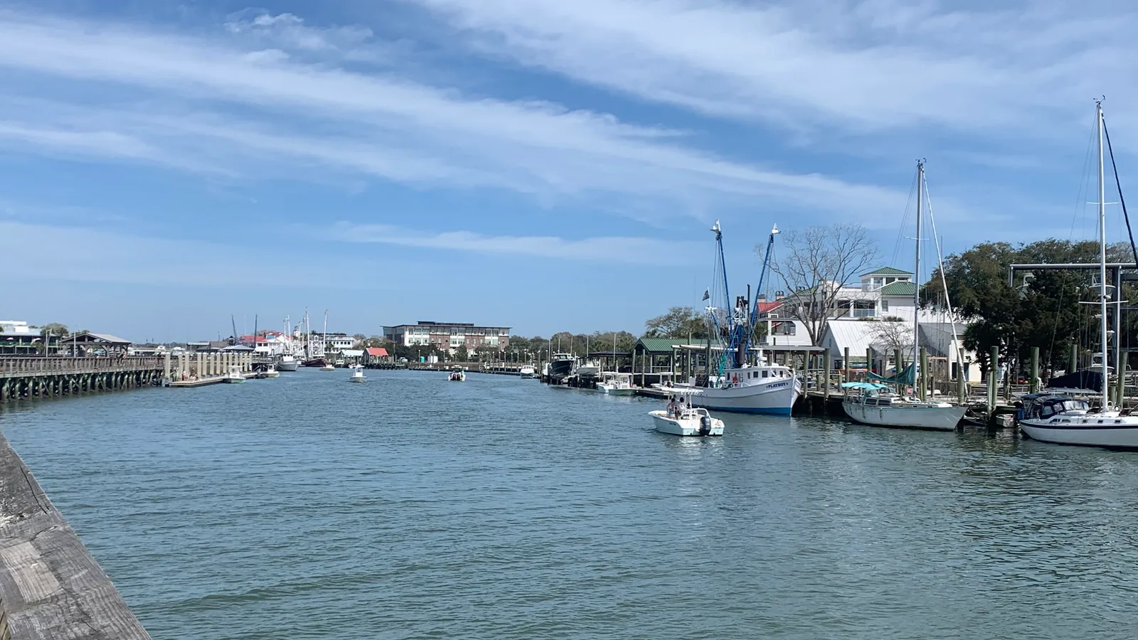 Shem Creek in Mount Pleasant, with the boardwalk on the left and boats tied up along the creek