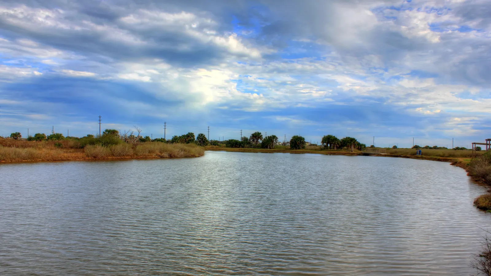 A bend in a long, calm estuary pond at Galveston Island State Park