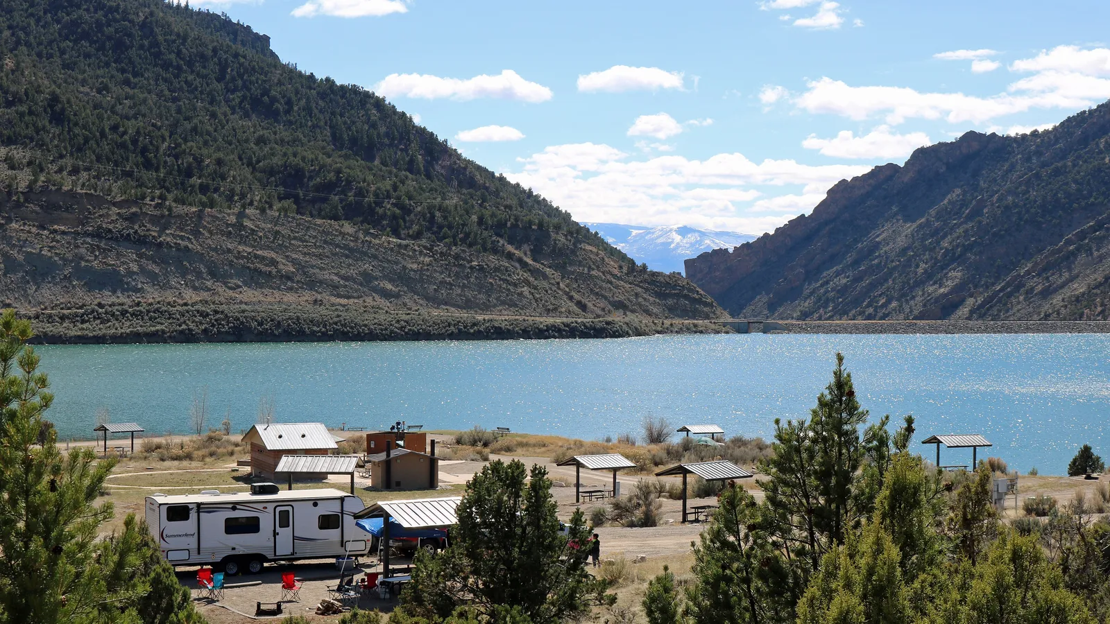 Rifle Gap Reservoir below sagebrush hills, with picnic shelters on the shore