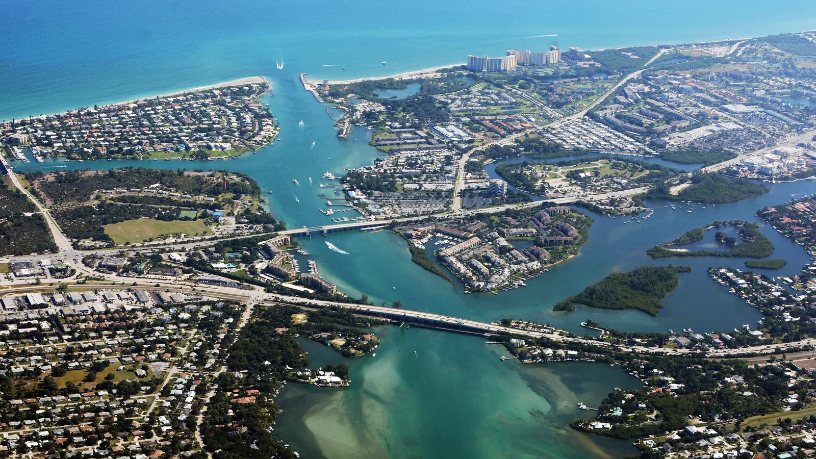 Aerial view of the Loxahatchee River winding to Jupiter Inlet, with shallow sandbars and the US 1 bridge