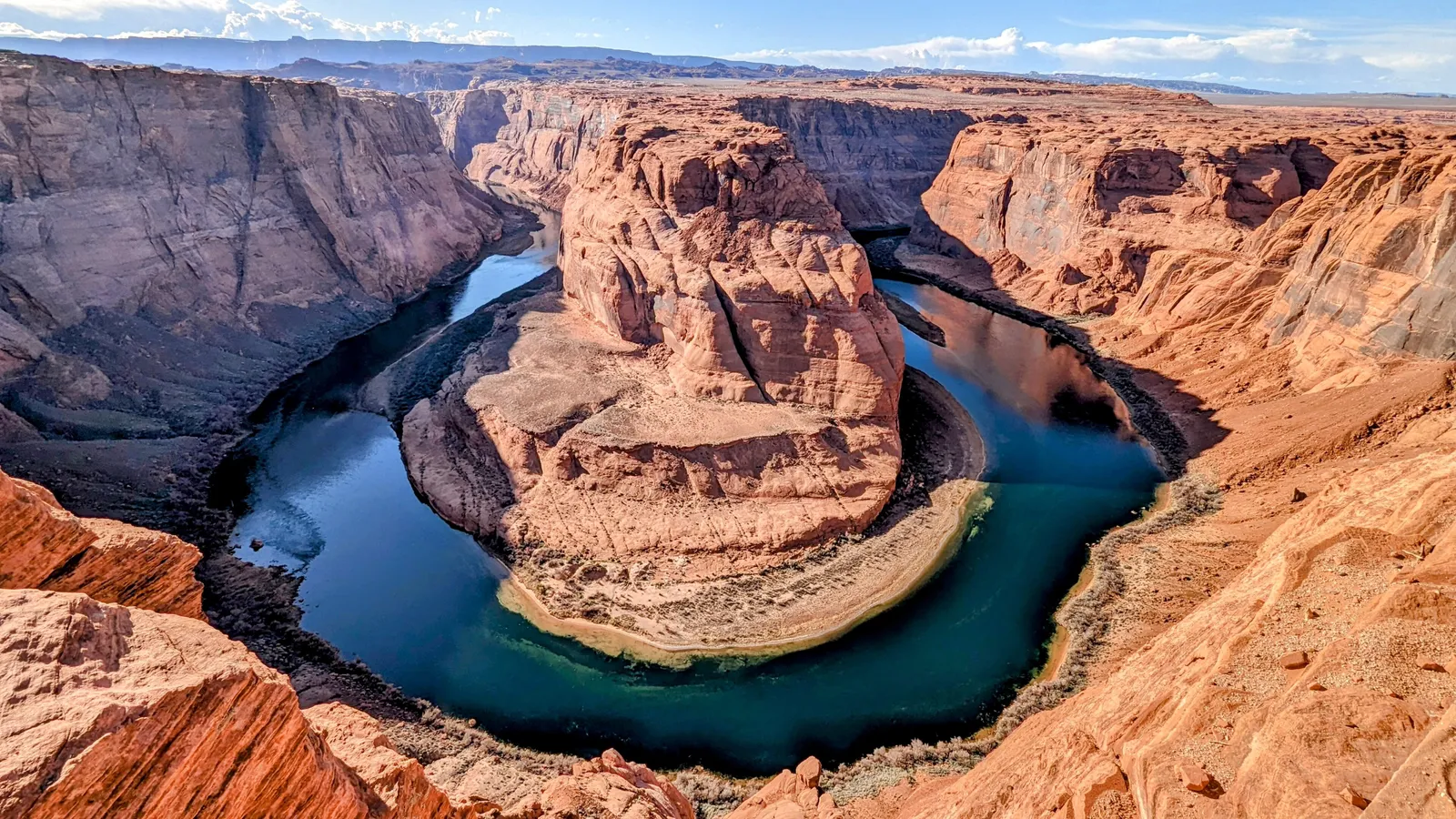 The Colorado River curving around Horseshoe Bend between red sandstone cliffs