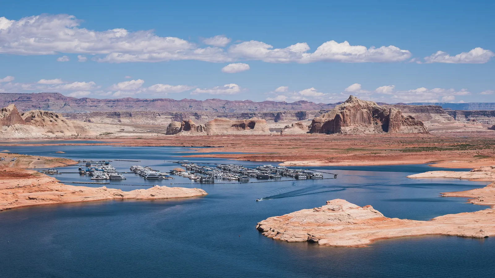Wahweap Marina's docks on Lake Powell, surrounded by sandstone islands and buttes