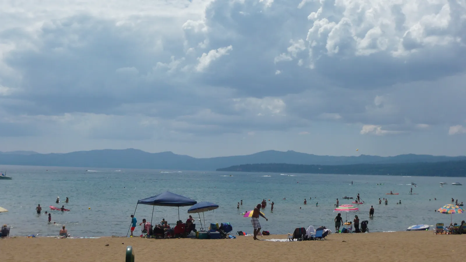 A busy summer day on the sand and in the shallows at Kings Beach State Recreation Area