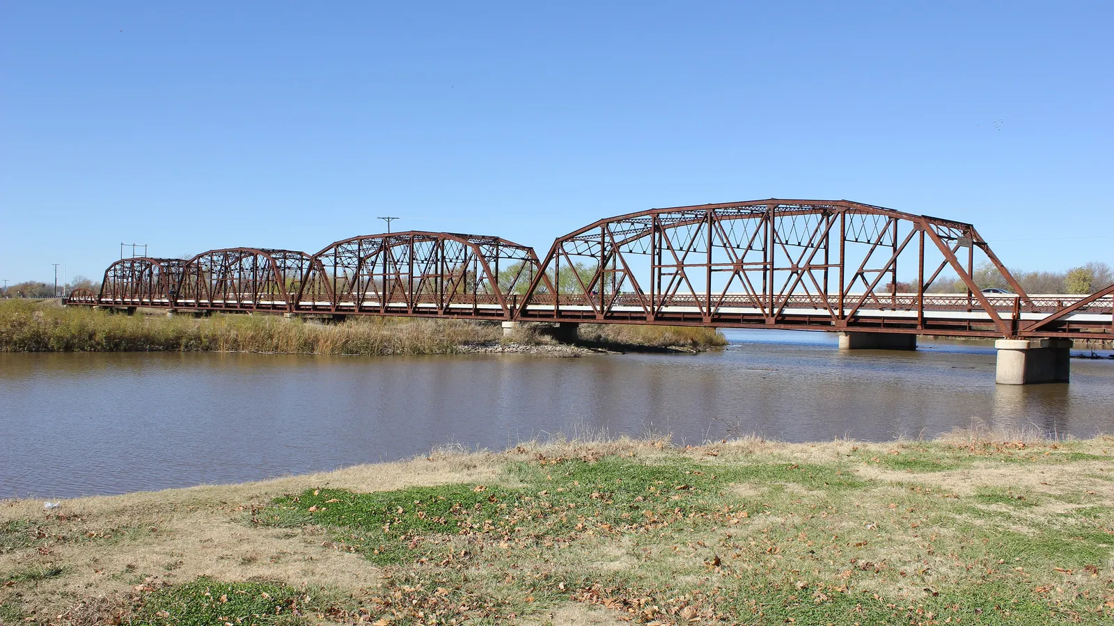 The rust-red Route 66 truss bridge over the North Canadian River at Lake Overholser