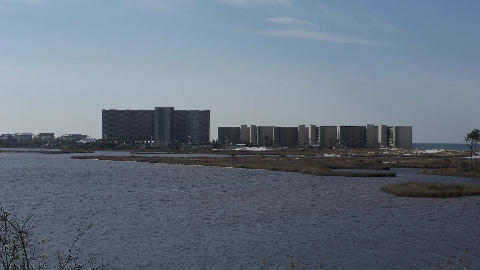 Lake Powell and its marshy shore at Camp Helen State Park, with beachfront condos beyond