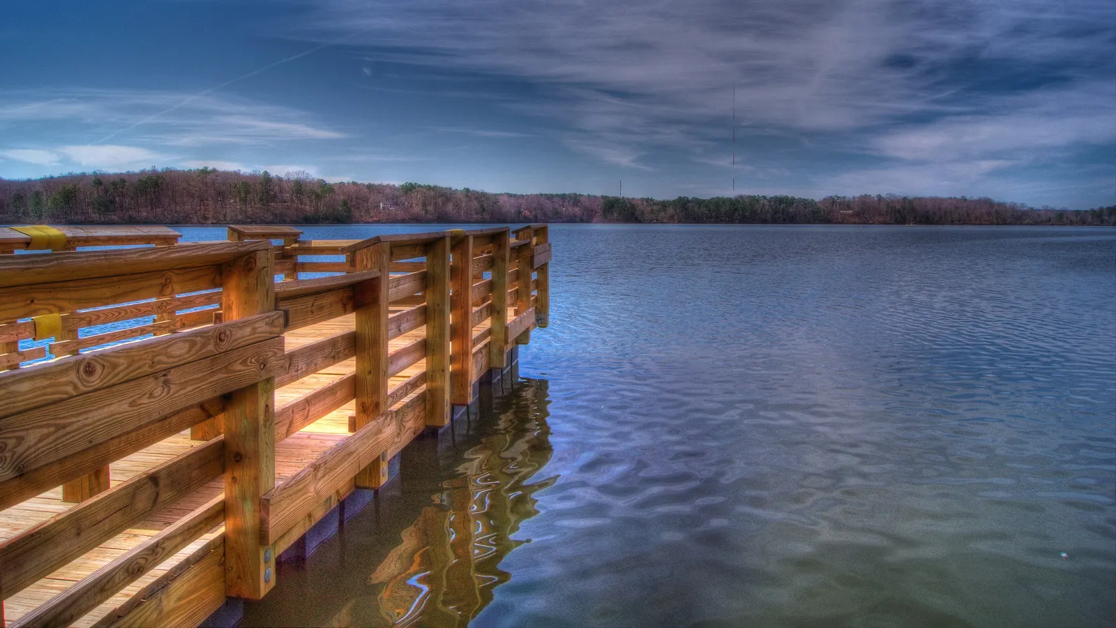 A wooden dock reaching out over Lake Wheeler on a clear day