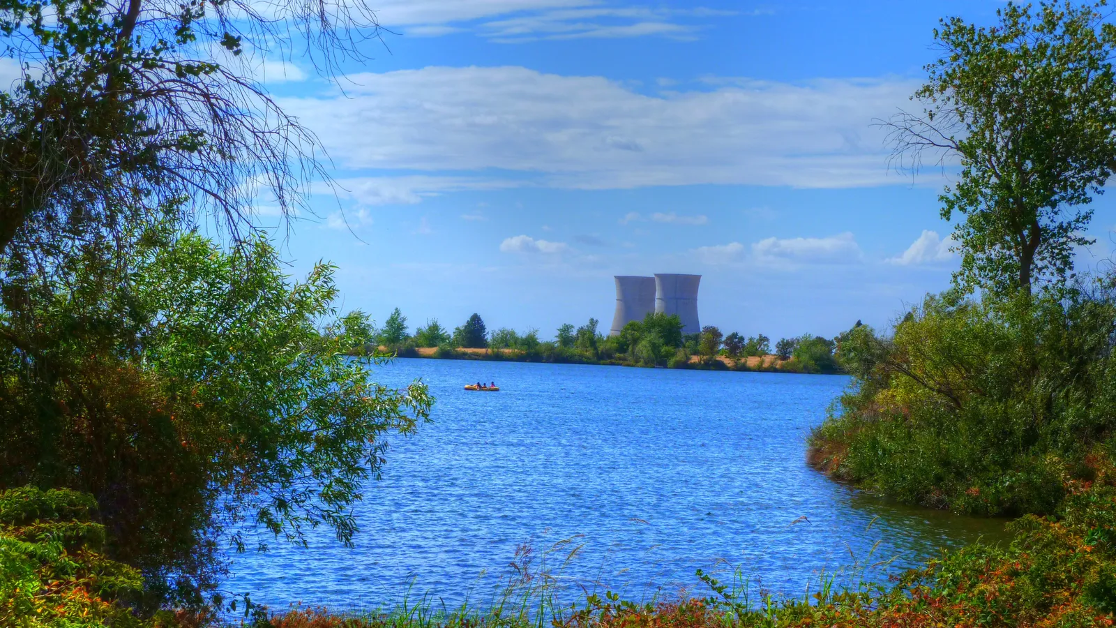 Rancho Seco Lake seen through trees, with the old power plant cooling towers in the distance