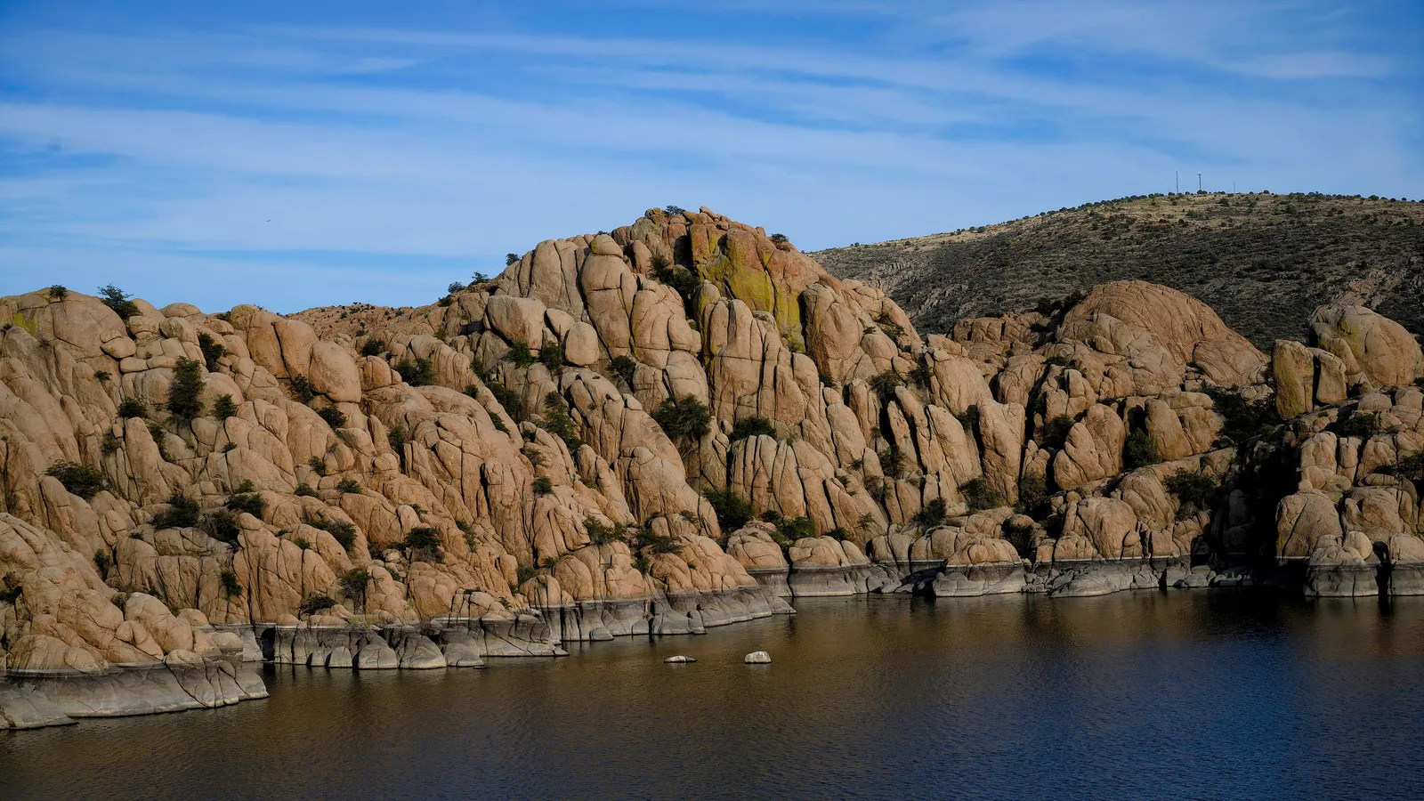 Rounded granite domes of the Granite Dells rising from Watson Lake