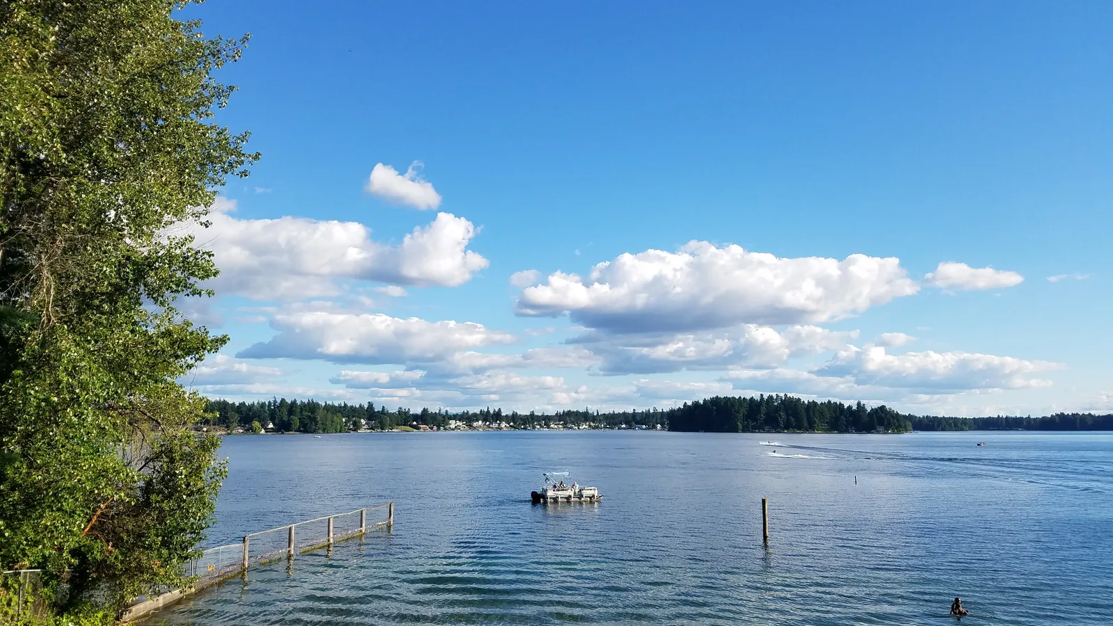 Blue water and a pontoon boat on American Lake on a summer day