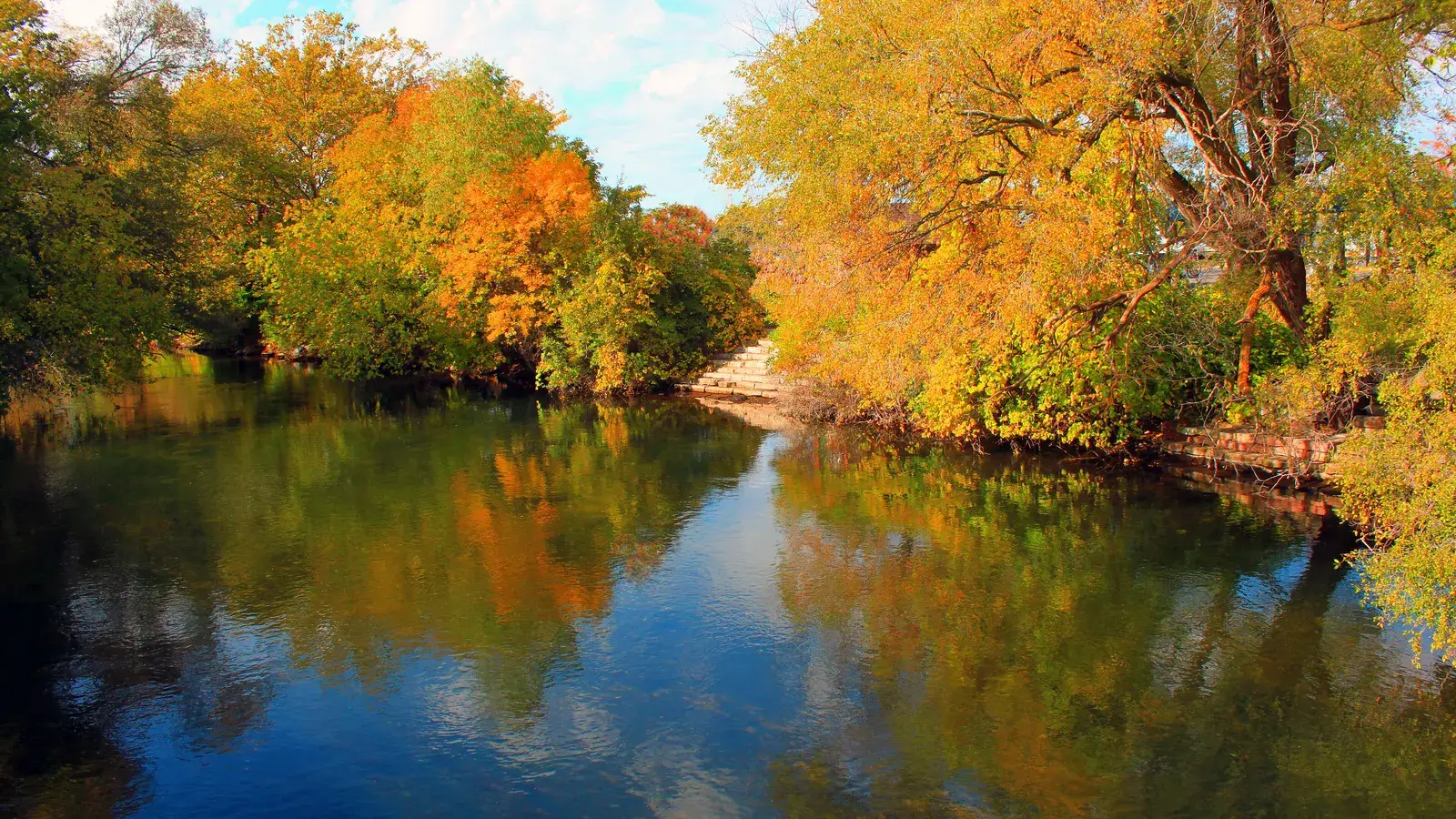 Fall colors reflected in the calm Boardman River in Traverse City