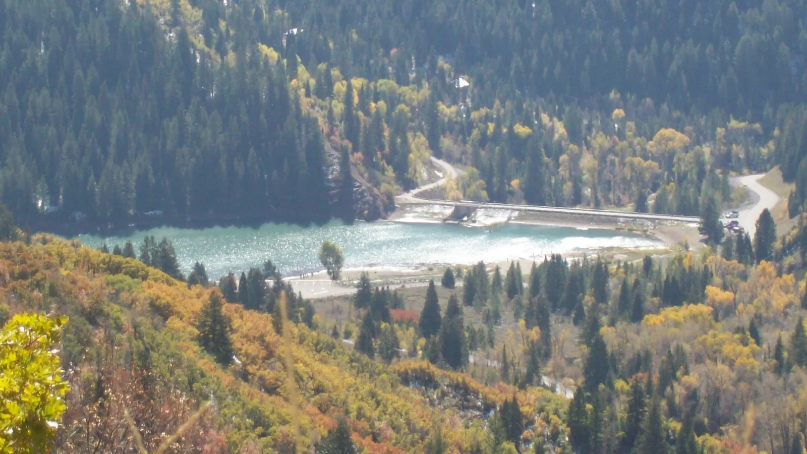 Tibble Fork Reservoir surrounded by autumn aspens and pines in American Fork Canyon