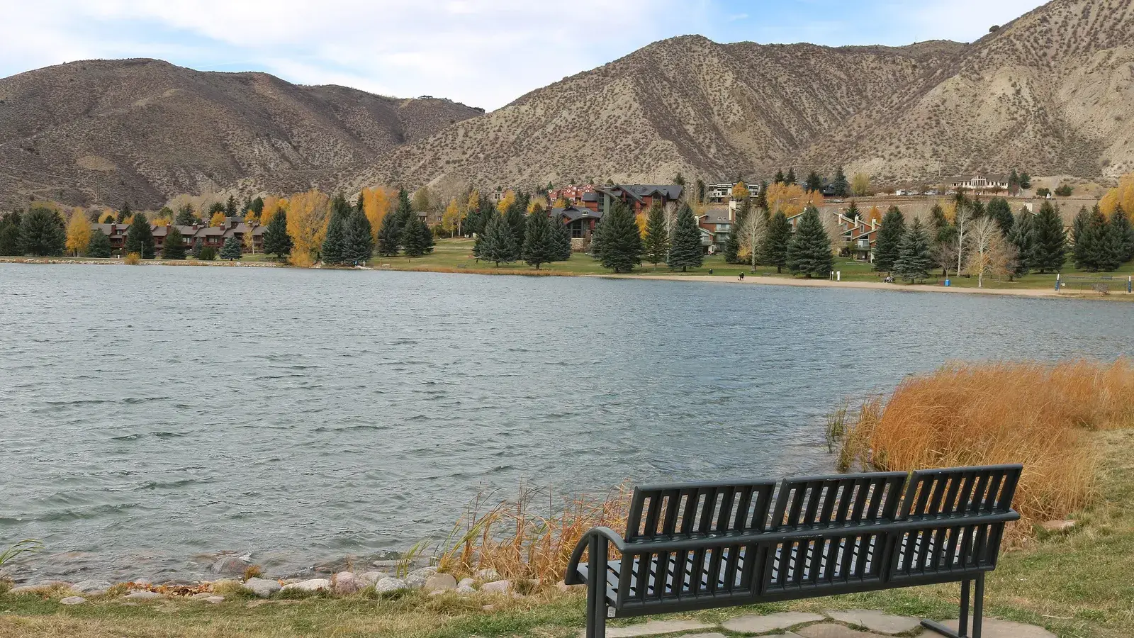Nottingham Lake in Avon with a bench on the shore and the hills above Beaver Creek behind