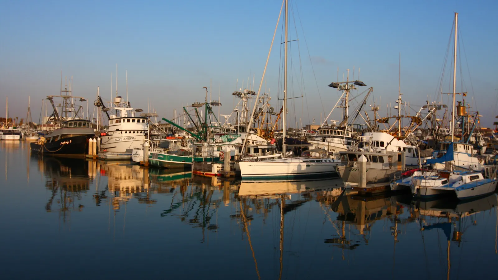 Fishing and pleasure boats reflected in the still water of Ventura Harbor