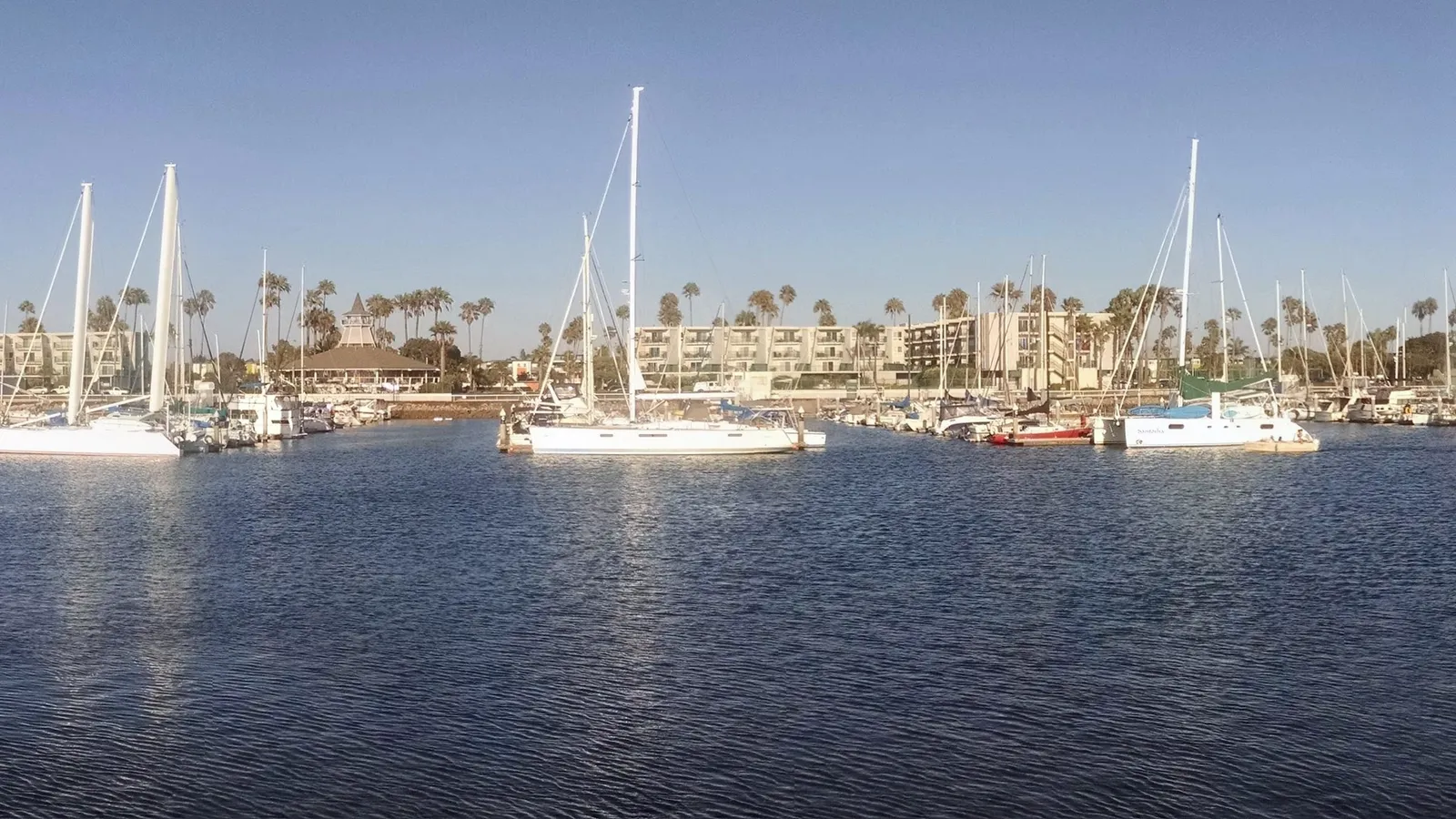 Sailboats on calm water in Channel Islands Harbor, looking east toward the peninsula