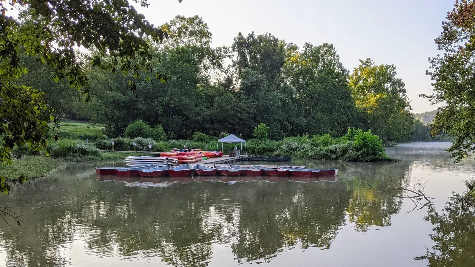 Red rental canoes tied up in the calm, tree-lined water of Fletcher's Cove on the Potomac