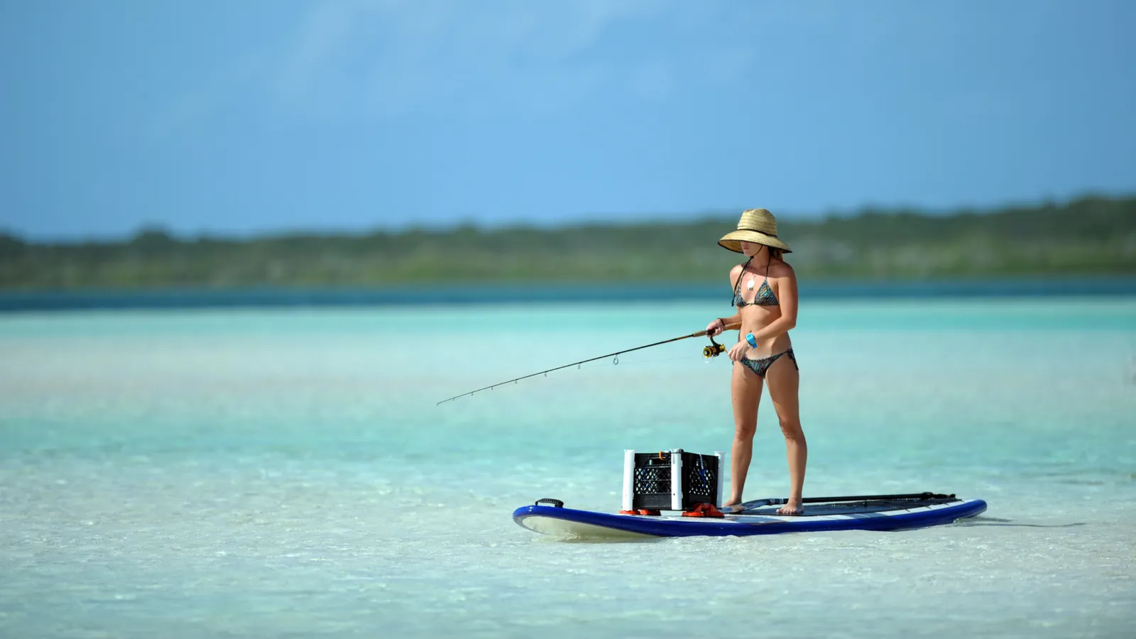 Angler sitting on a paddle board to fish