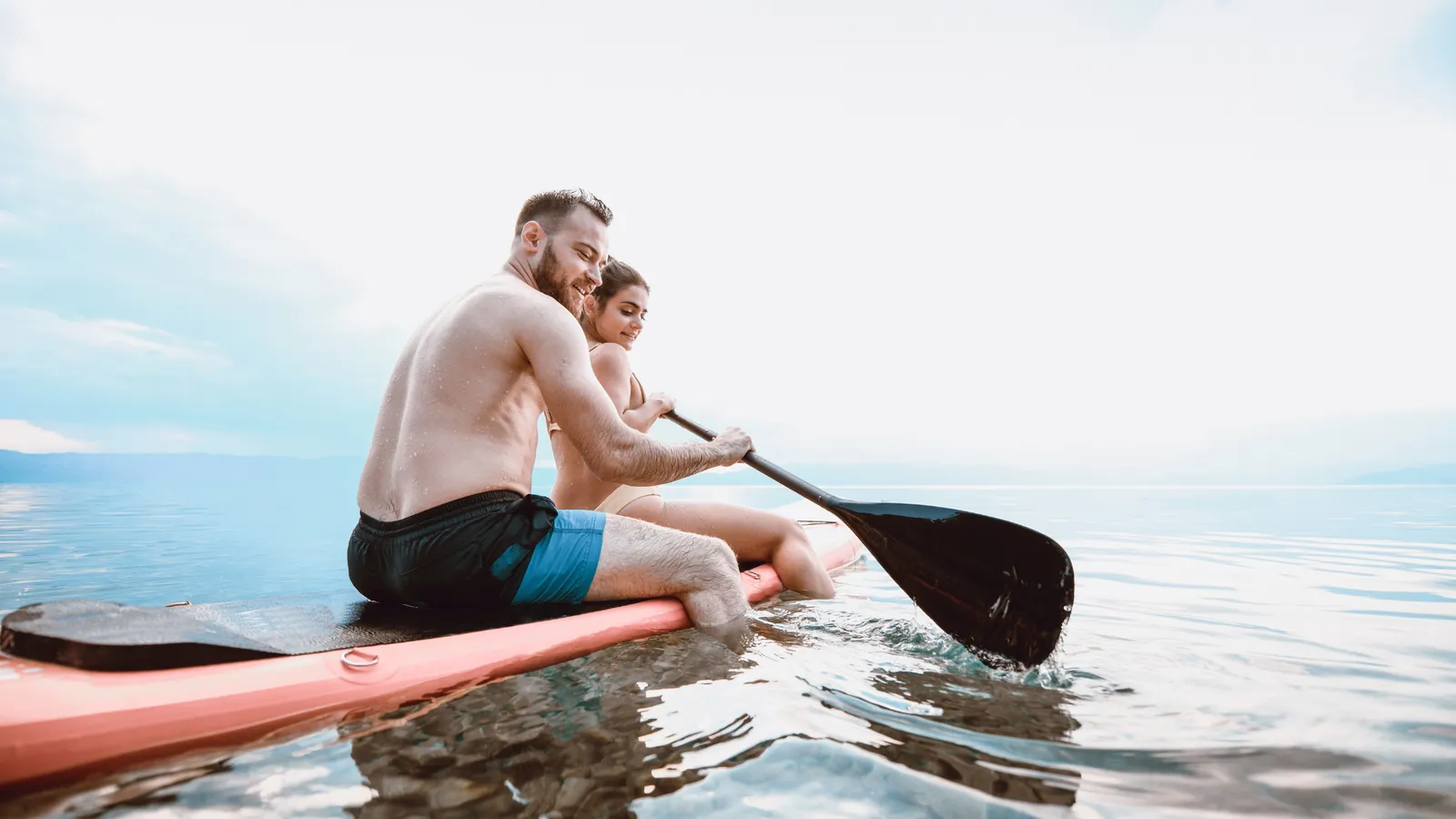 Paddleboarder in swimwear on warm water