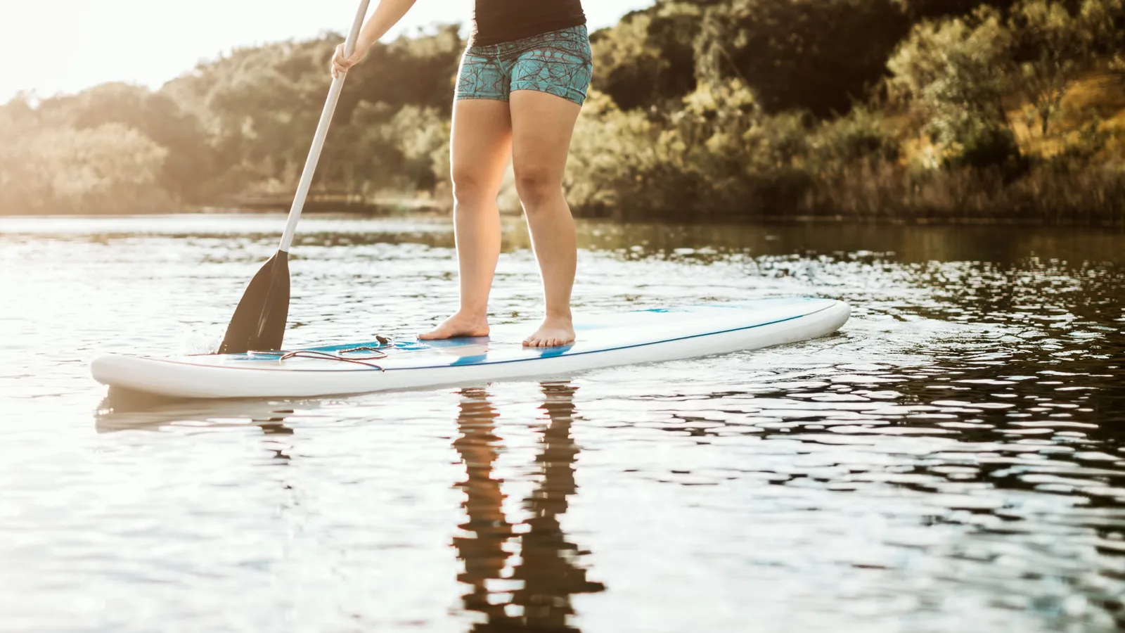 Beginner paddle boarder standing on a wide board